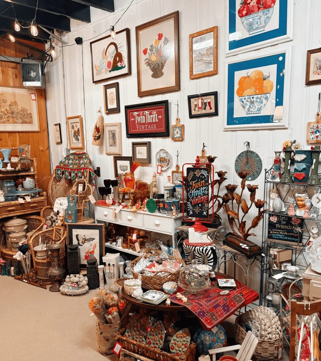 Wall decorated with framed artwork and decorative items, shelves with various collectibles, and a table with assorted objects.