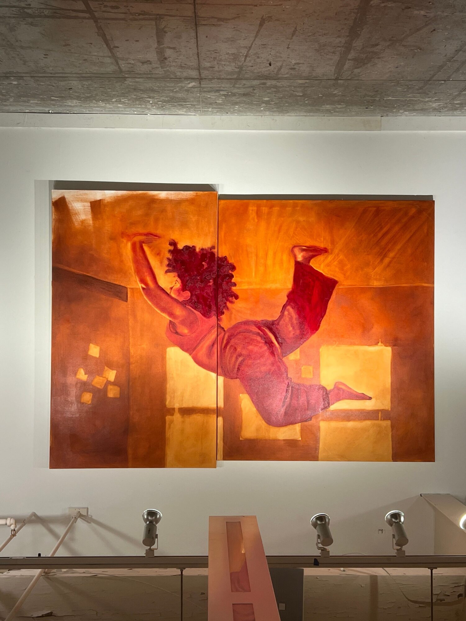 Painting of a person jumping with a bouquet, divided into four panels with warm colors, on a white wall.