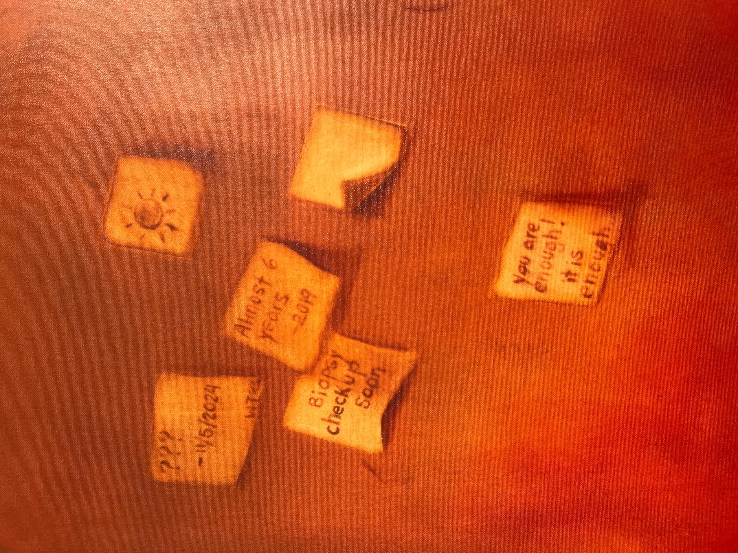 Four sticky notes on a surface with handwritten text, some notes are tilted, with a reddish background.