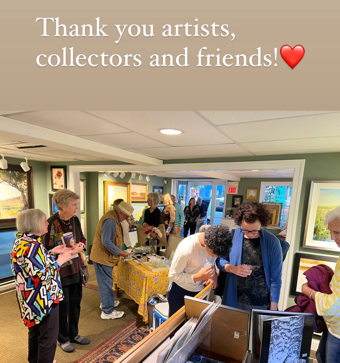 Group of people gathered around tables in an art gallery, some looking at artwork, others talking, with a message of thanks at the top.