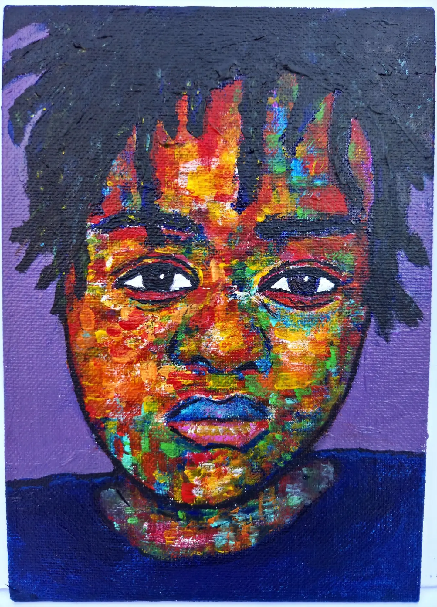 Portrait of a young person with colorful, textured face and dark hair, against a purple background.