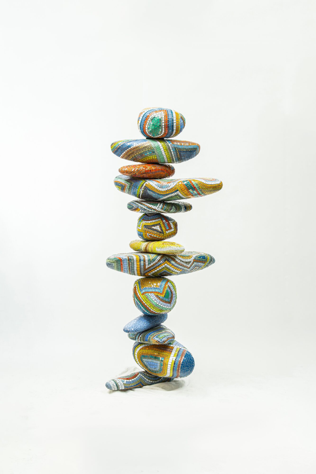 Stacked colorful stones arranged vertically on a white background.