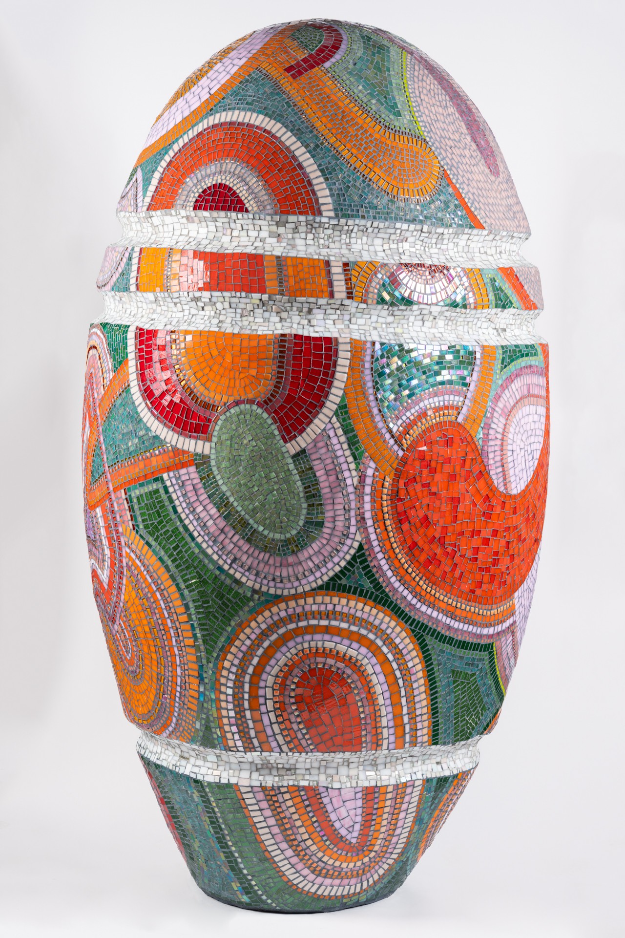 Decorative oval object with colorful abstract patterns and concentric circles, divided into three horizontal sections.