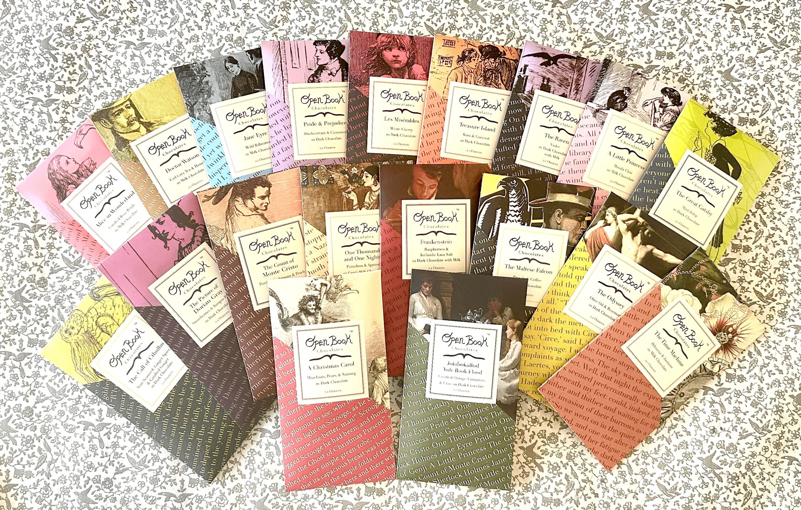 Multiple colorful booklets arranged in a semi-circle on a speckled surface, each with a label on the cover.