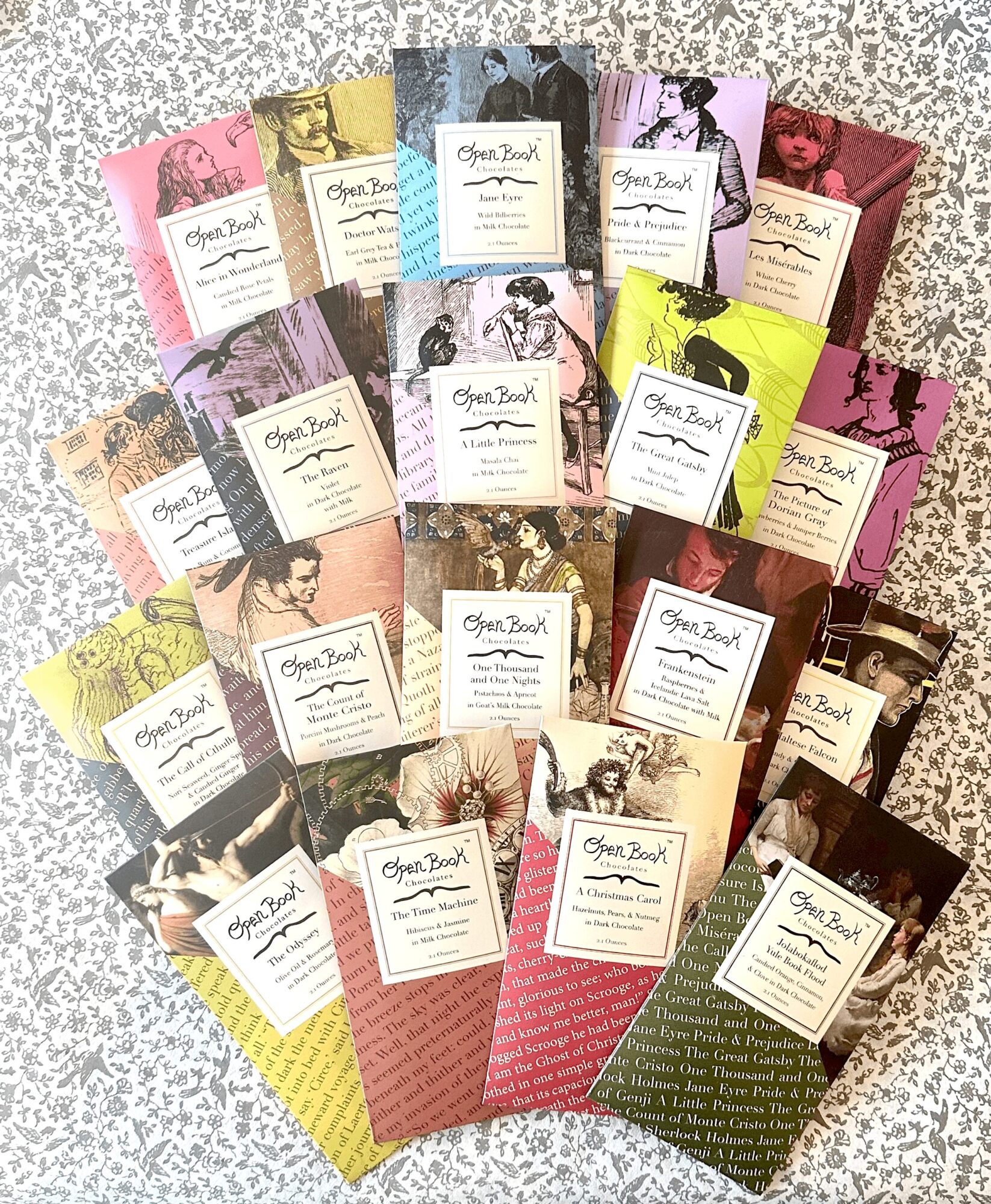 Collection of colorful books with illustrated covers arranged on a speckled surface.