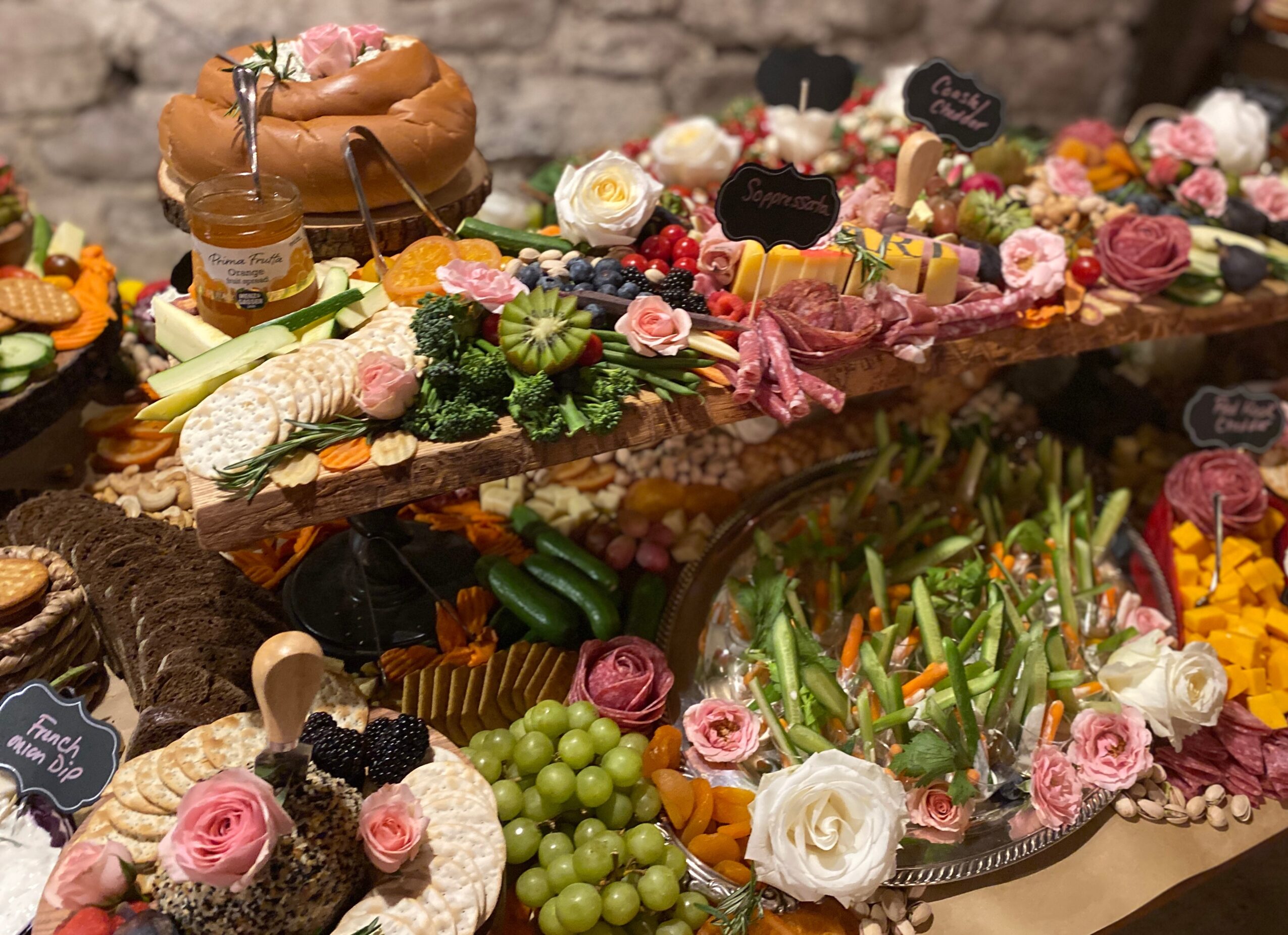 Assorted desserts and fruits arranged on a table with flowers and decorative items.