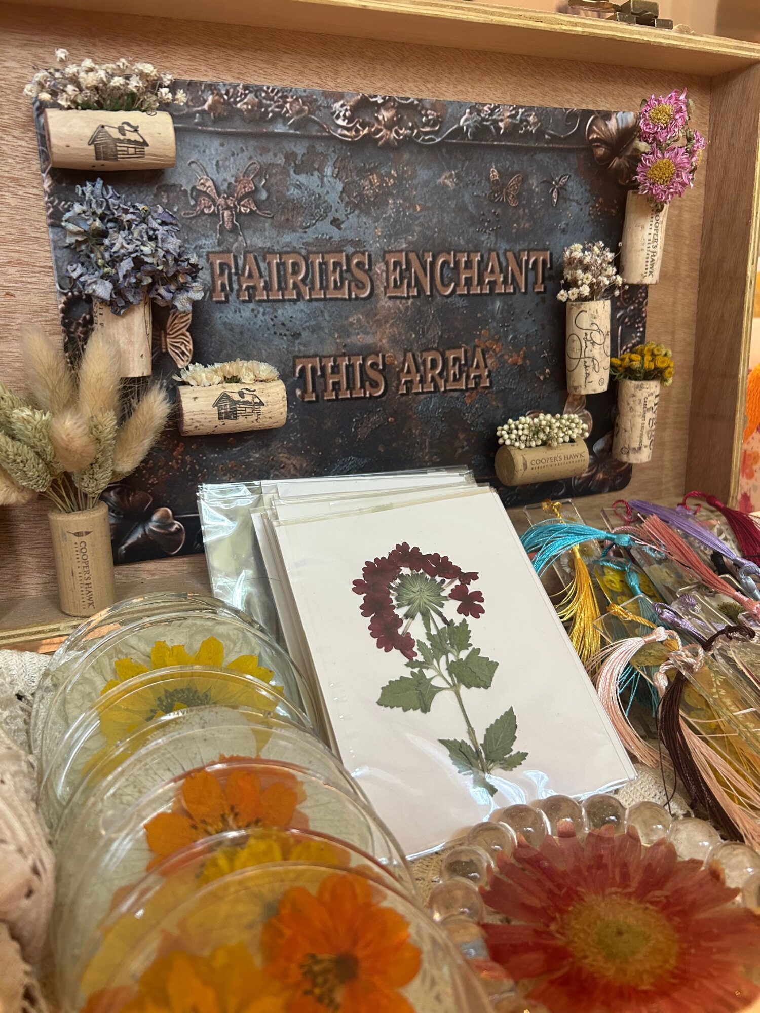 Display of flowers, a chalkboard with writing, and a paper with a flower illustration on a table.