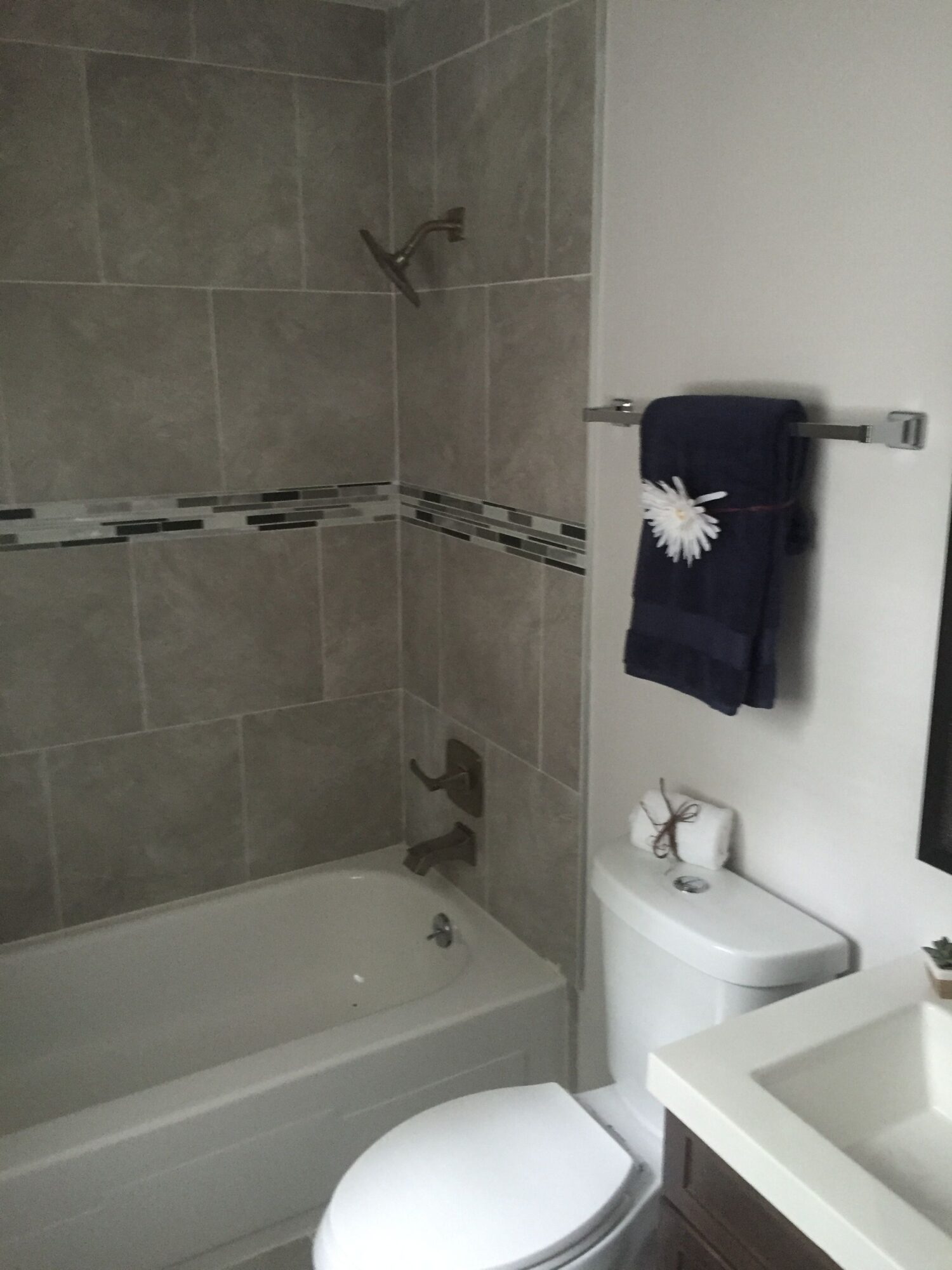 Bathroom with bathtub, toilet, towel rack, and sink, viewed from the side, with the image rotated 90 degrees clockwise.