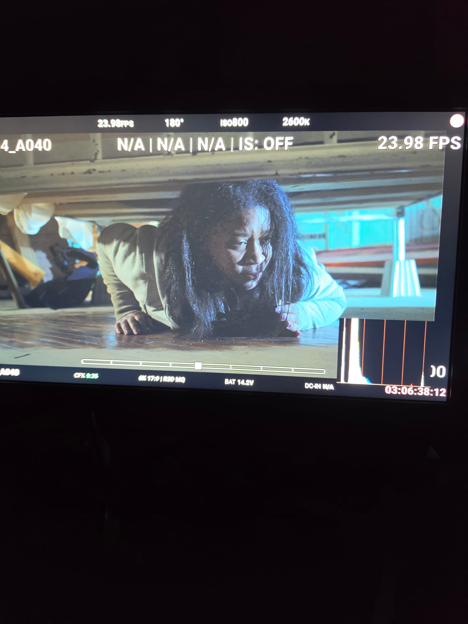Person with long hair leaning on a surface, looking down, in a room with blue and yellow elements.
