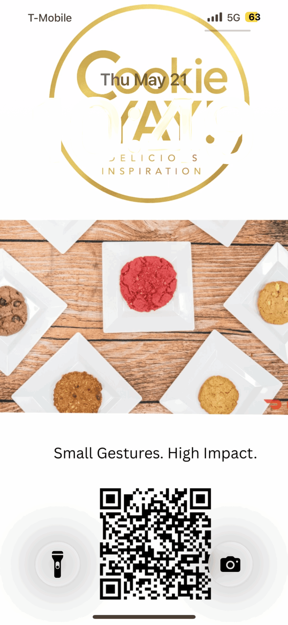 Six small cookies on white plates arranged on a wooden surface, with a red cookie in the center, and a QR code below.