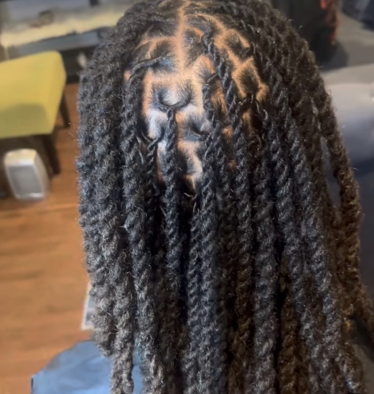 Close-up of a person's head with styled, twisted natural hair, showing the scalp and hair pattern.