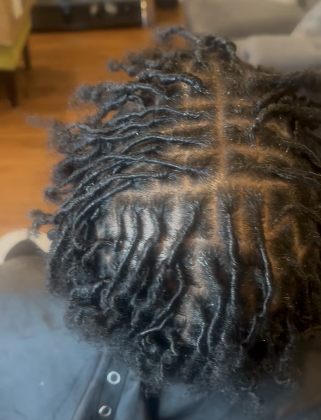 Top view of a person's hair styled in thick, twisted locs with a visible parting line.