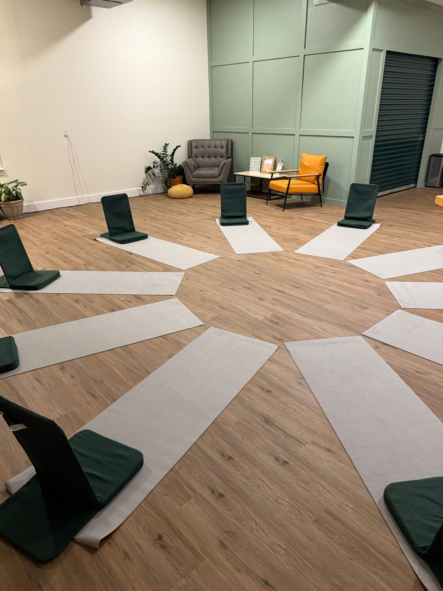 Conference room with chairs arranged around a circular pattern on the floor, and a table with a yellow bag and other items.