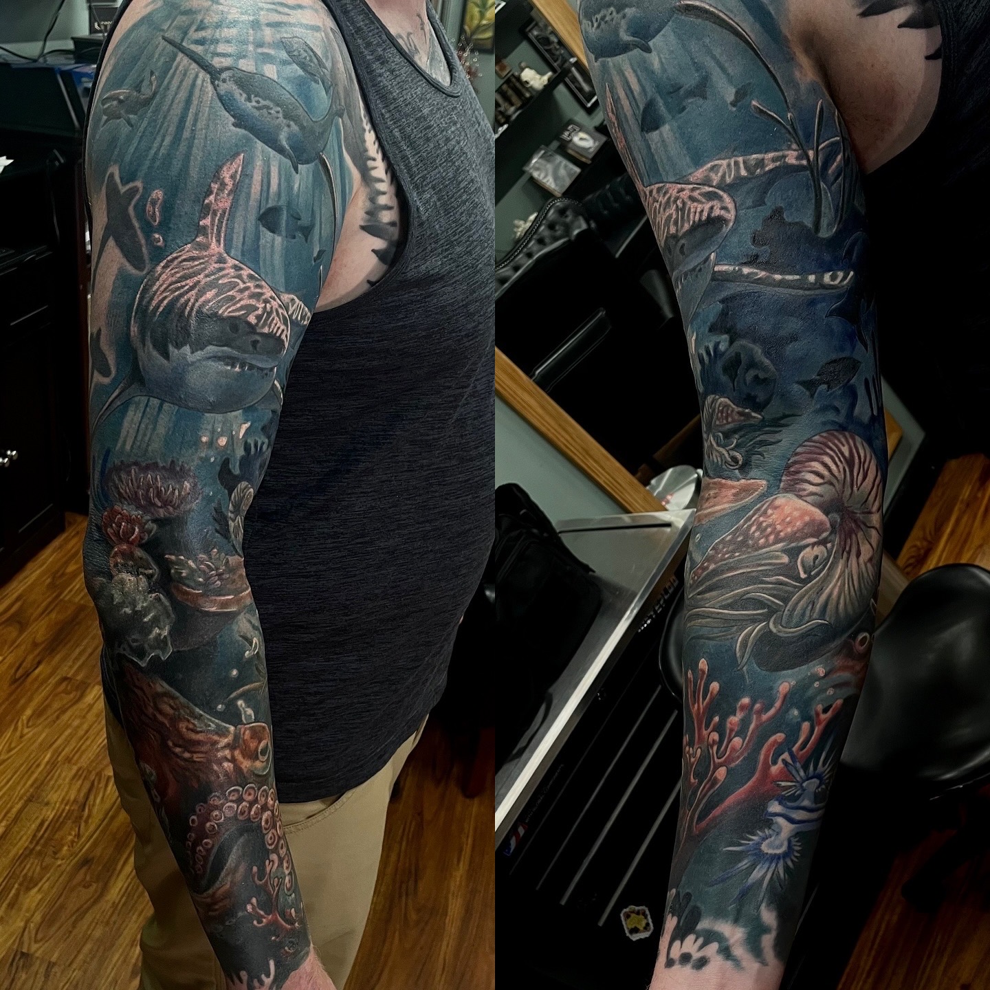 Person with colorful full sleeve tattoo, wearing a dark sleeveless shirt, standing indoors with wooden floor and furniture.