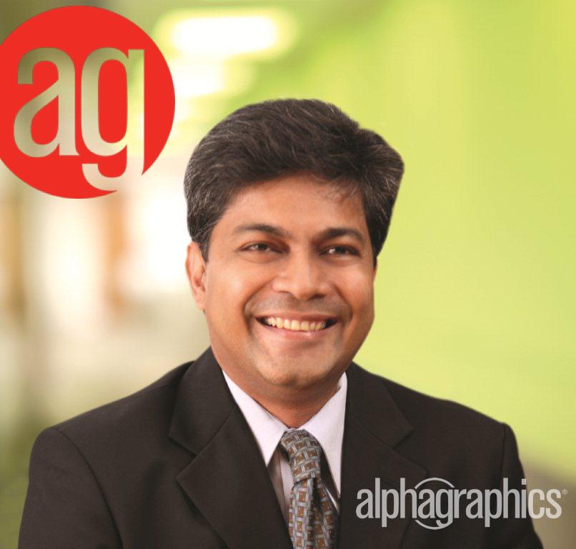 Smiling man in a suit with a blurred green background, red 'ag' logo in top left corner, 'alphagraphics' text in bottom right.