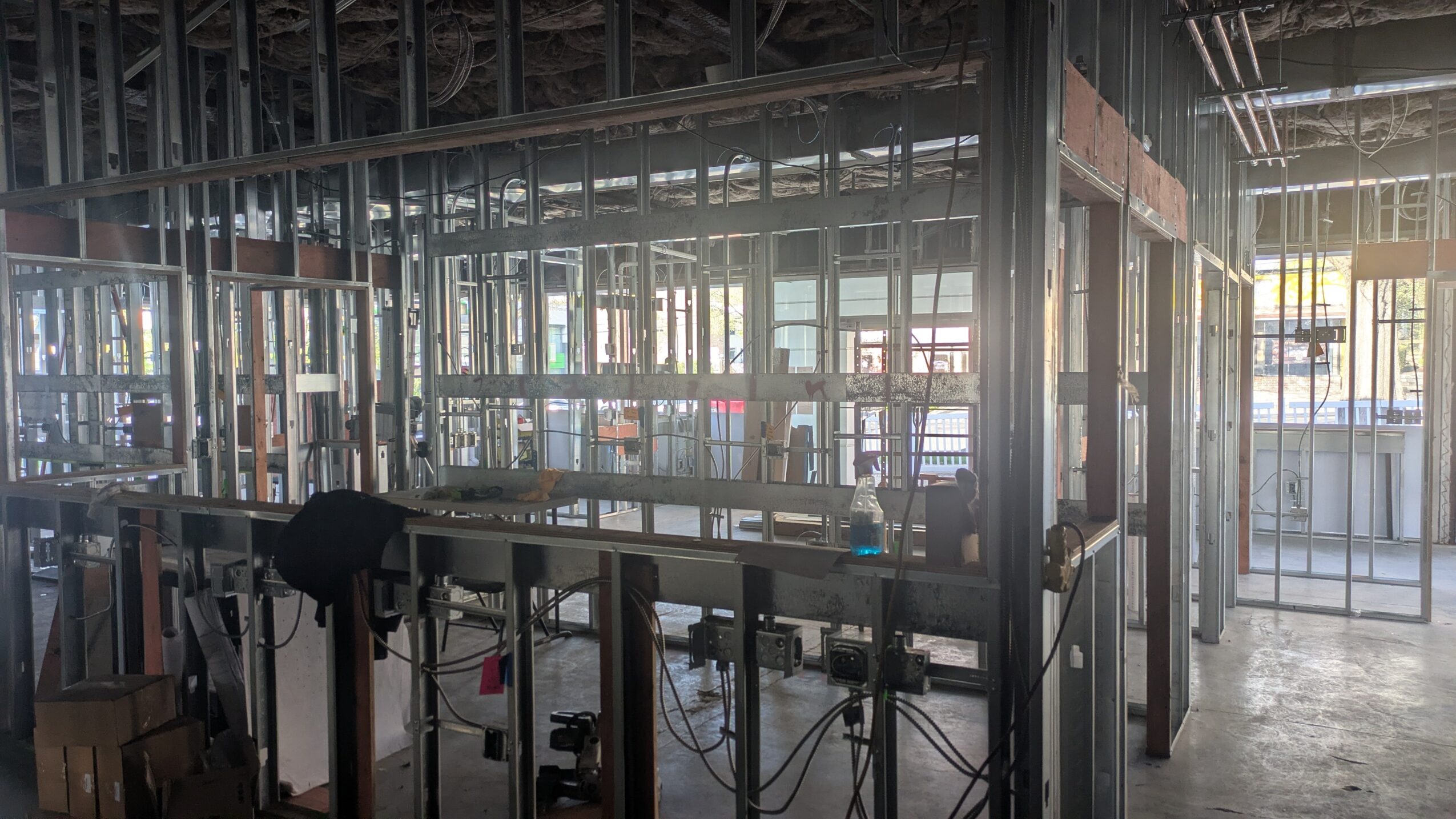 Construction site with metal framing and equipment inside a partially built structure.