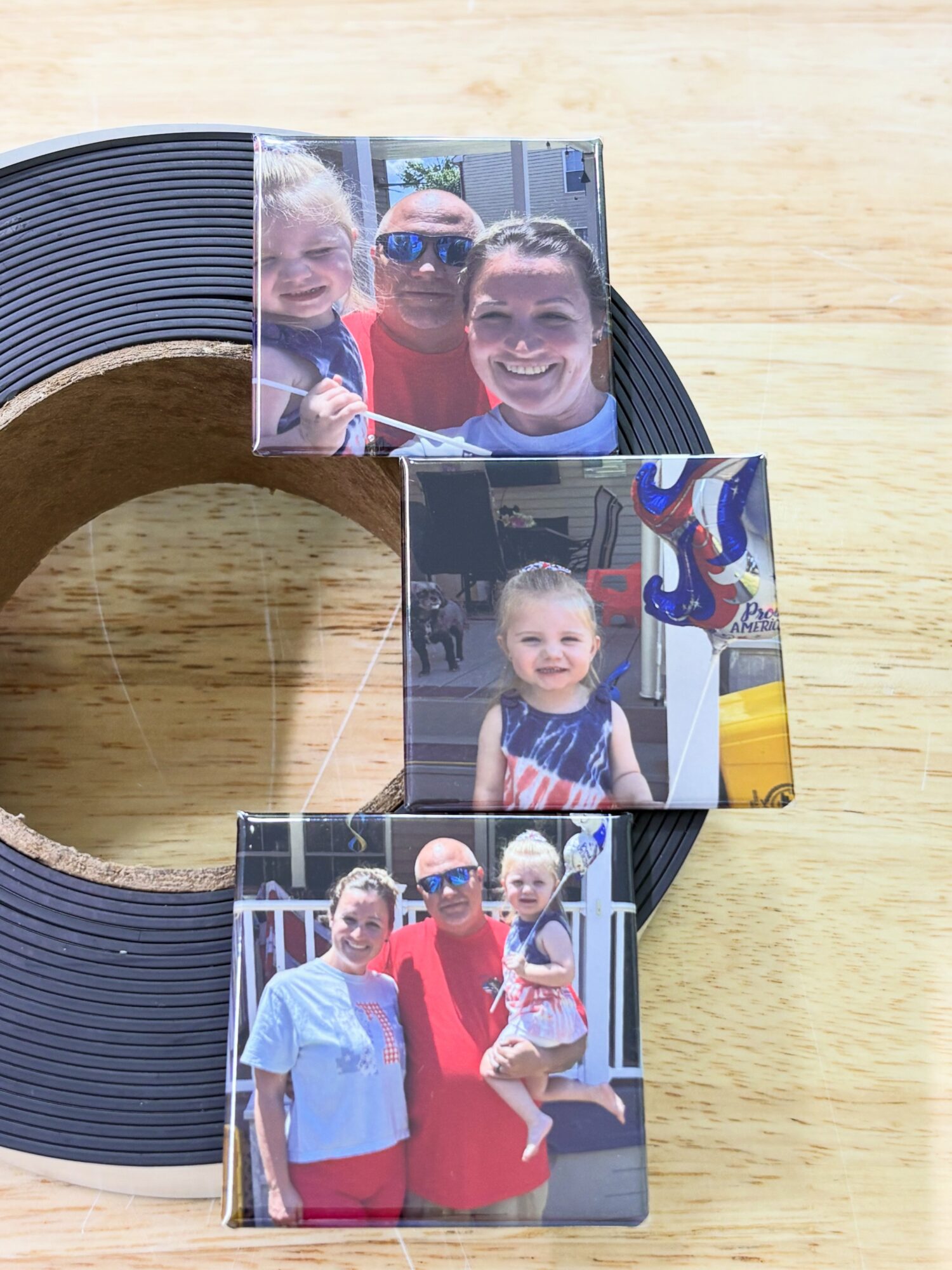 Three photos of children and adults on a table, with a black circular object behind them.