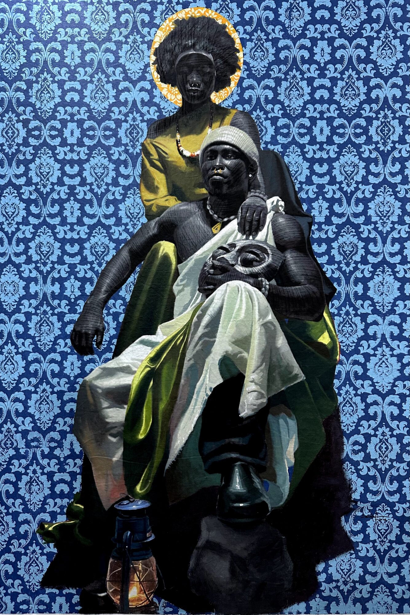 Statue of two women, one seated holding a skull, the other standing behind, against a blue patterned background.