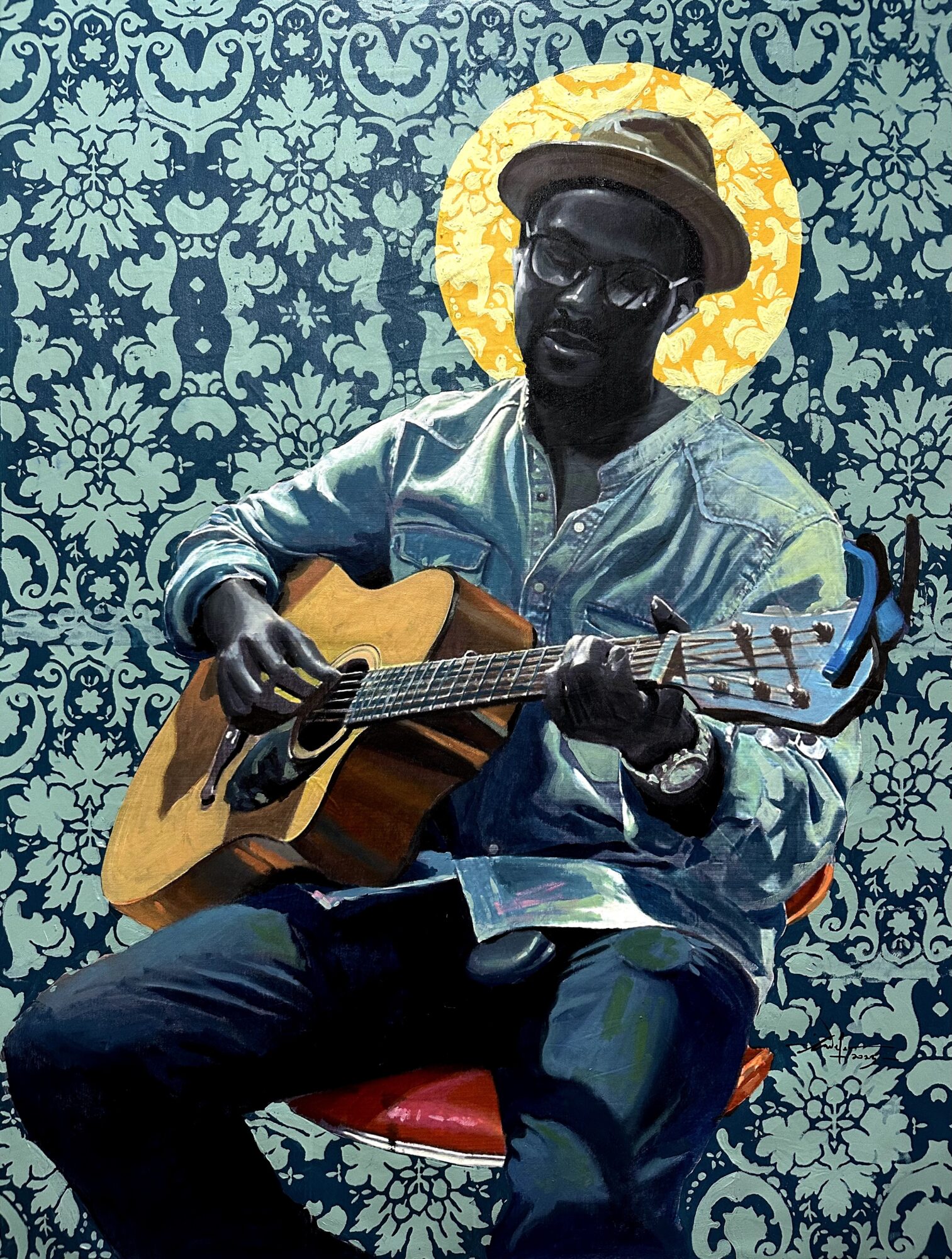 Person playing guitar, wearing glasses, hat, and denim jacket, seated against a patterned background with a halo-like circle behind head.