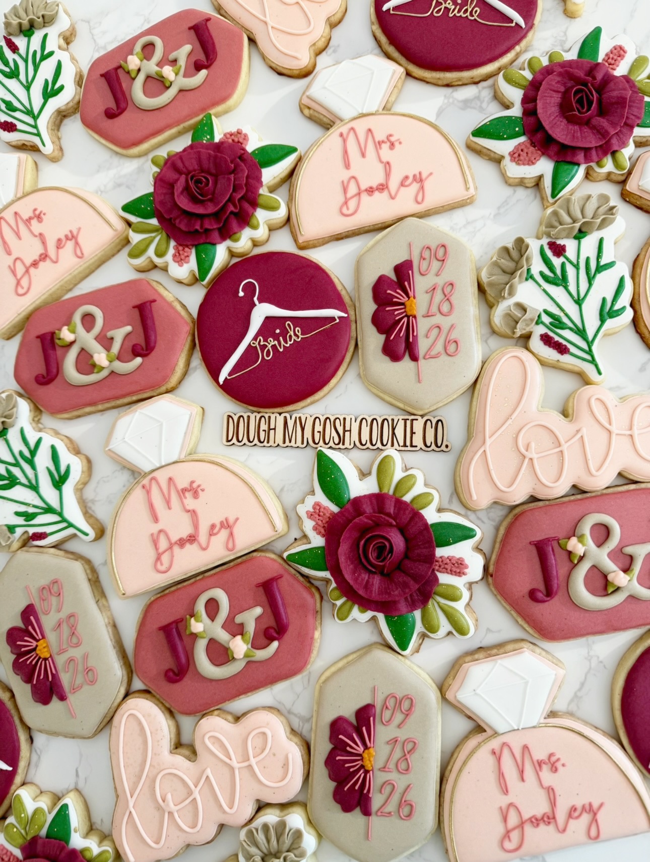 Decorative cookies with wedding and love themes, including flowers, hearts, and text like