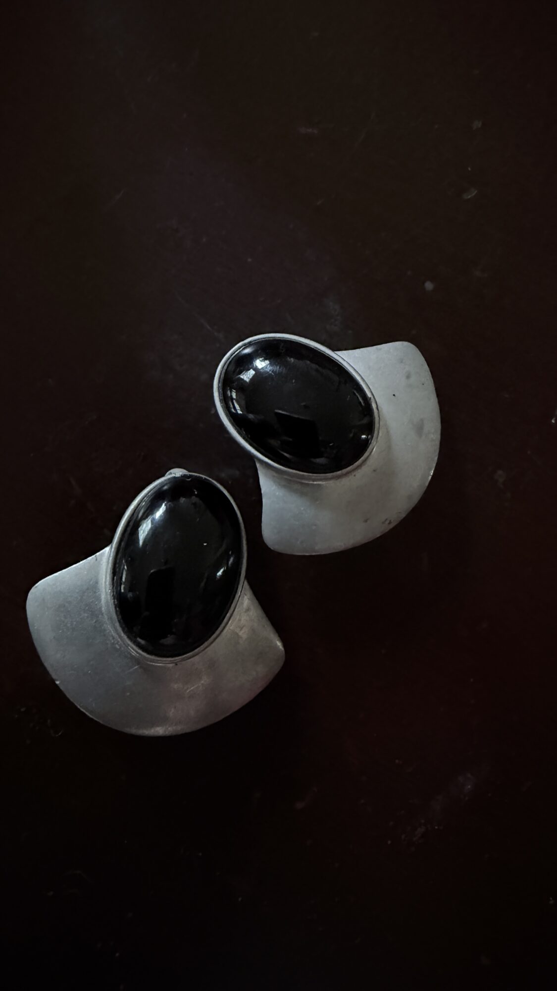 Two security cameras on a dark surface, angled upward, with black domes and white bases.