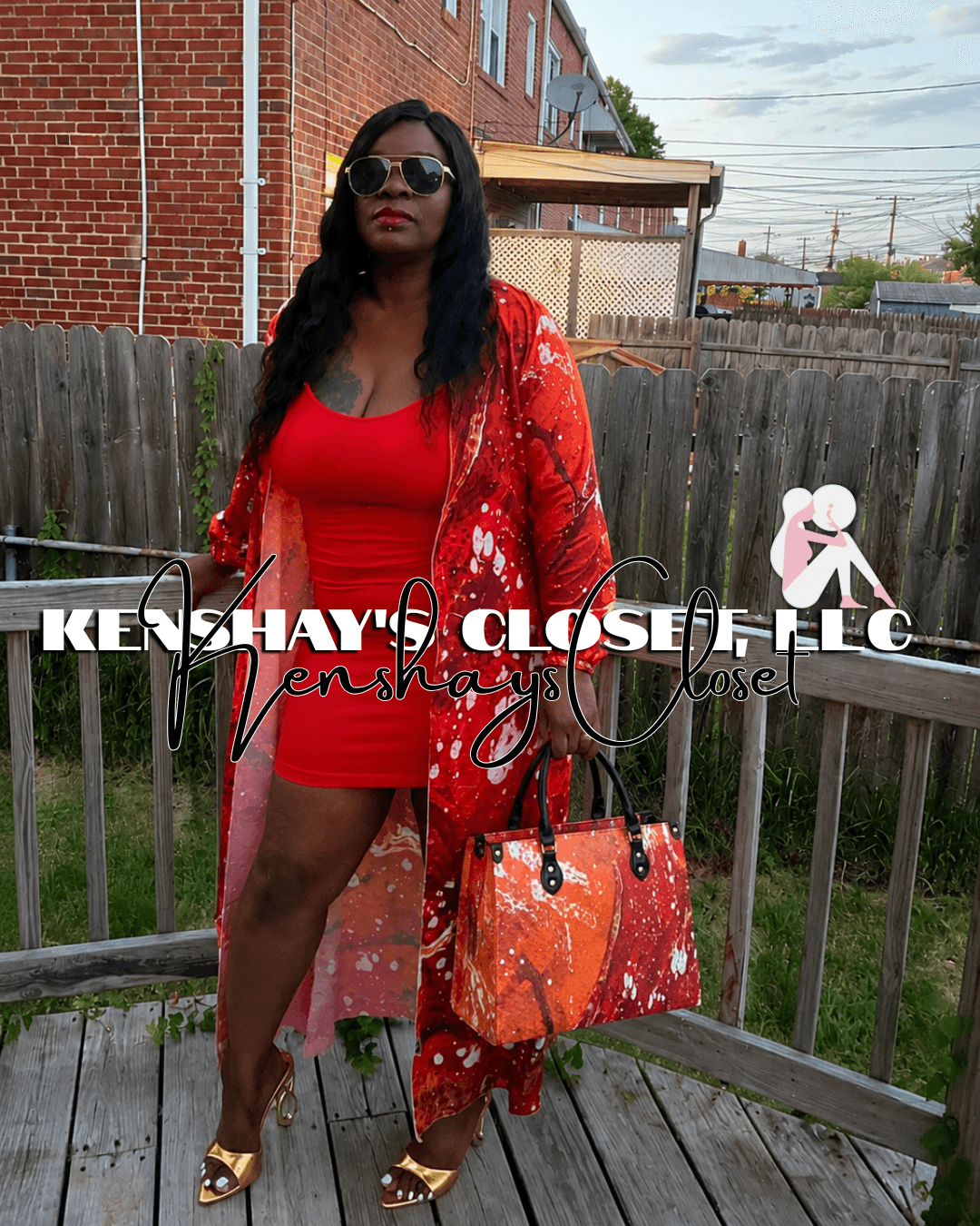 Woman in red dress and sunglasses standing on a wooden deck with a fence and buildings in background.