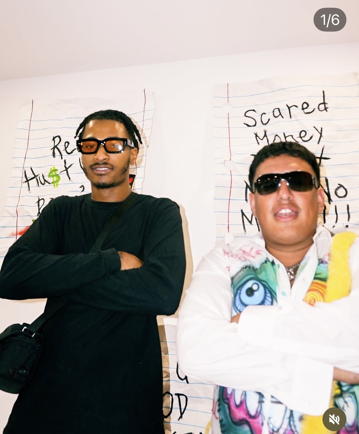 Two people wearing sunglasses standing in front of whiteboards with handwritten notes, arms crossed, smiling.