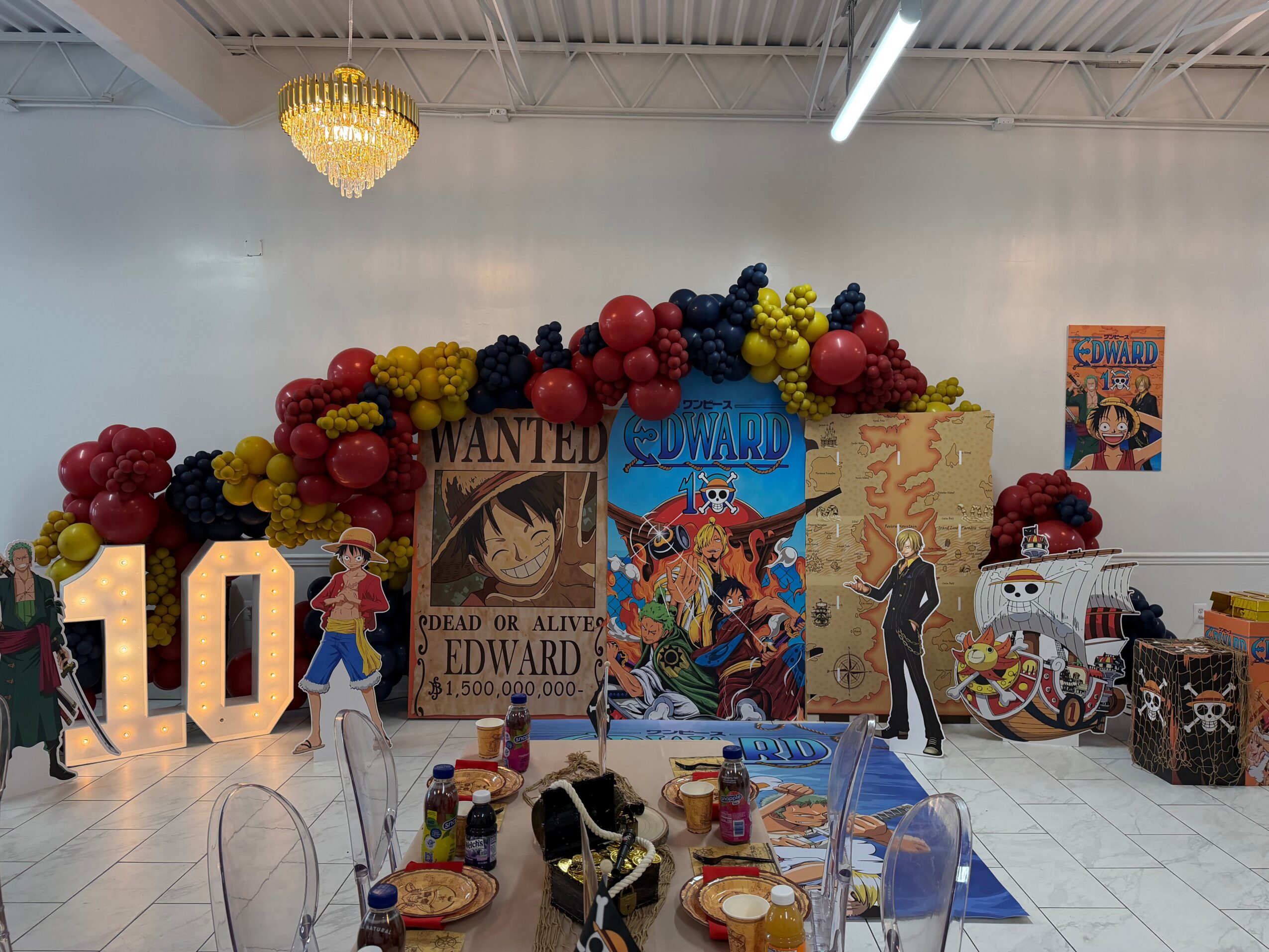 Decorative display with balloons, posters, and a large illuminated number 10, themed around a cartoon or comic character, in a spacious room.