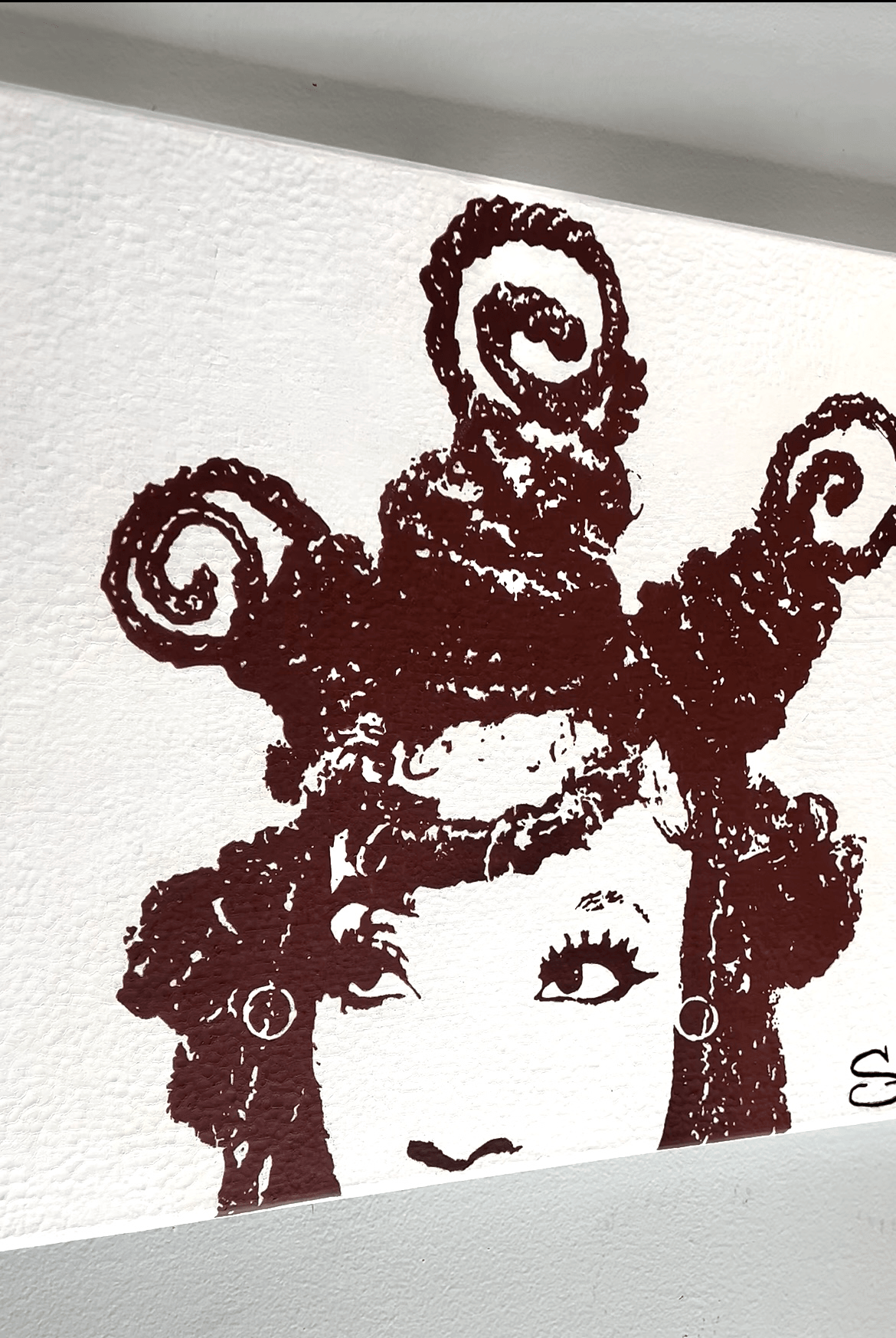 Black and white illustration of a woman's face with curly hair and an elaborate, curly hairstyle on top.