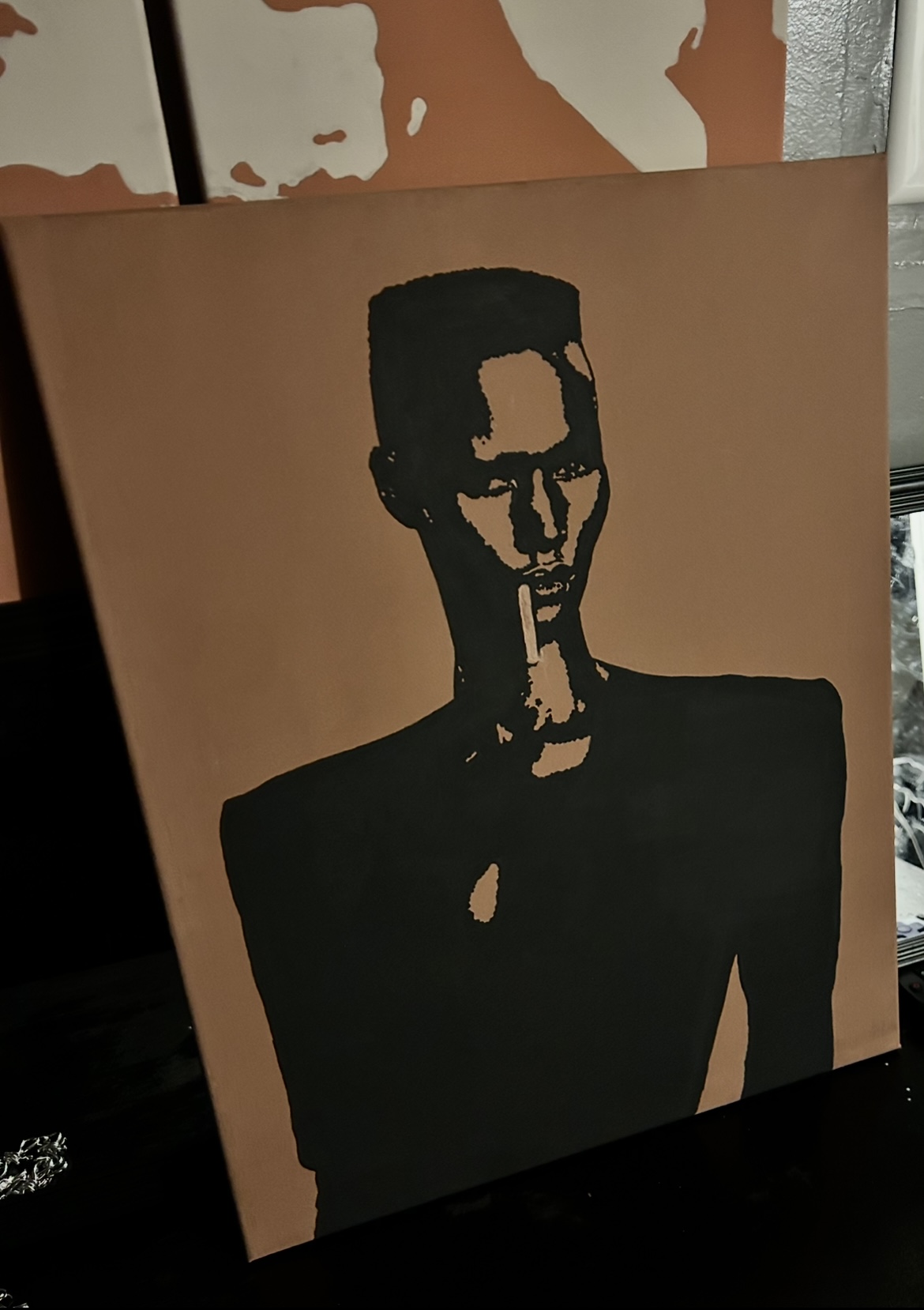 Silhouette of a person with glasses and short hair, wearing a dark shirt, against a light background.