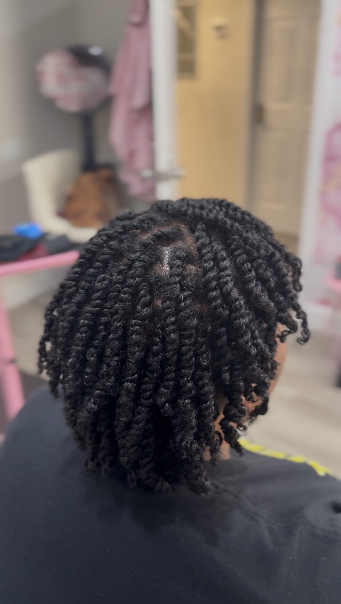 Top view of a person's head with textured, twisted hair styled in small twists.