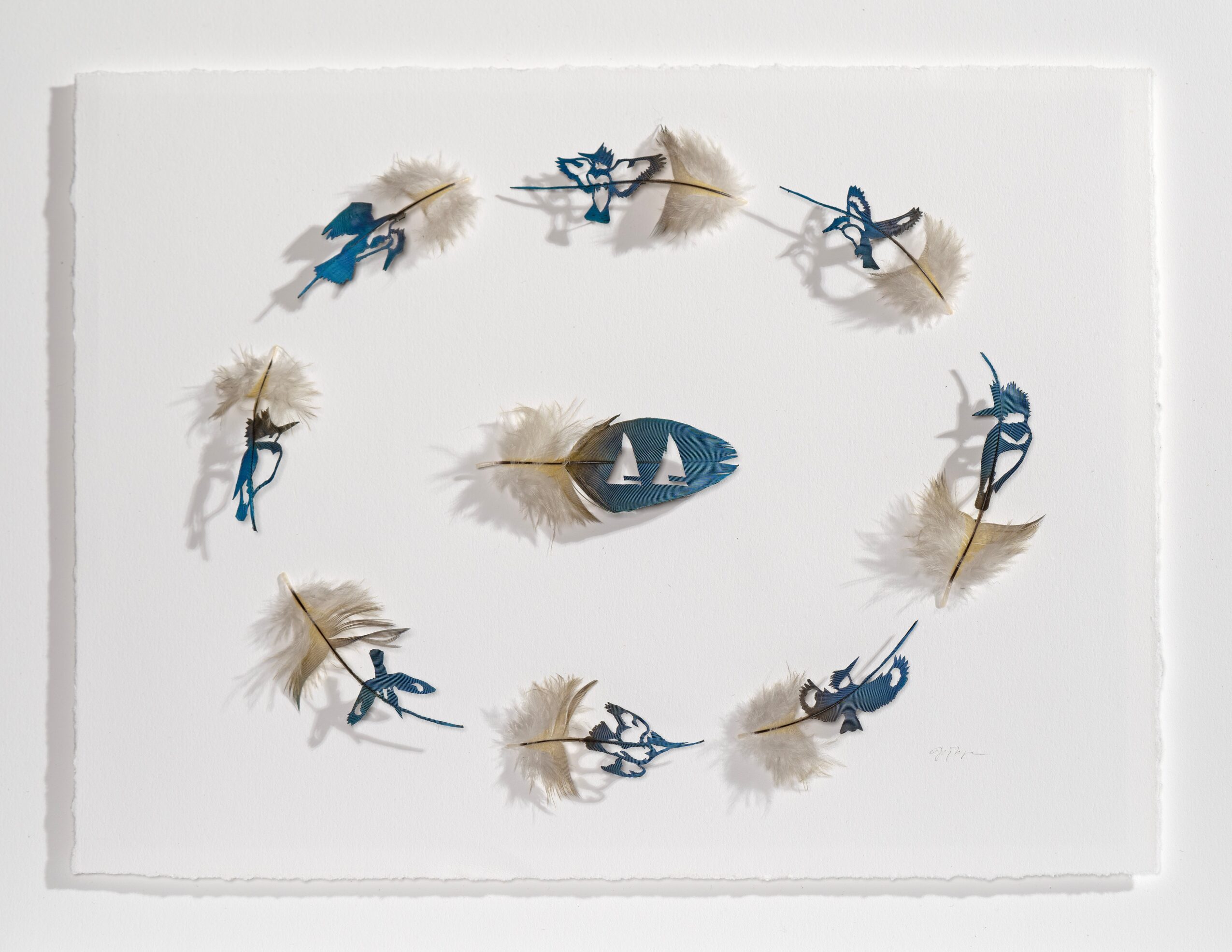 Decorative wall clock with blue figures and feathers, featuring a boat in the center, arranged in a circular pattern.