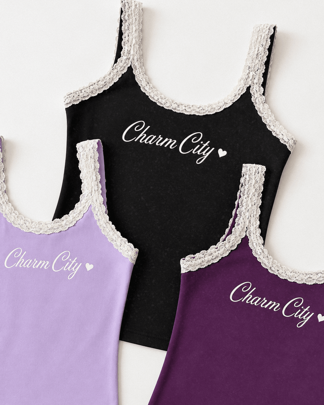 Three tank tops with lace trim, black, purple, and lavender, displayed flat, with