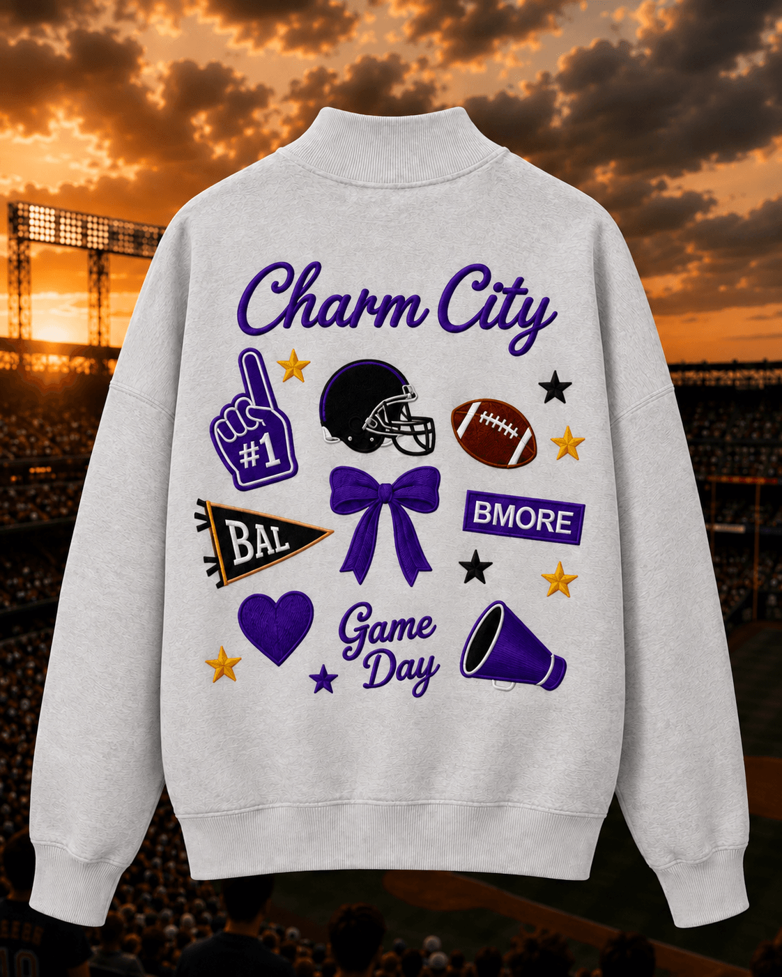 Gray sweatshirt with football-themed graphics and text, including a helmet, football, purple bow, and various symbols, on a stadium background.