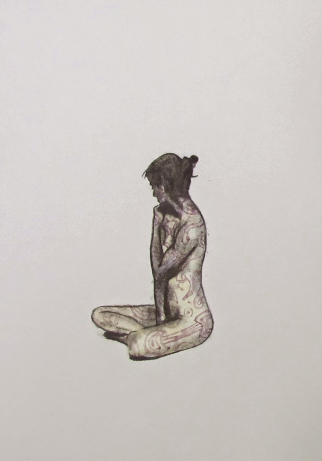 A person with long hair sits cross-legged on the floor, facing sideways, with a plain light background.