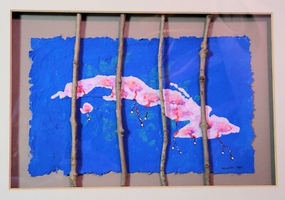 Abstract artwork with a blue background, pink and white cloud-like shape, and vertical wooden sticks.