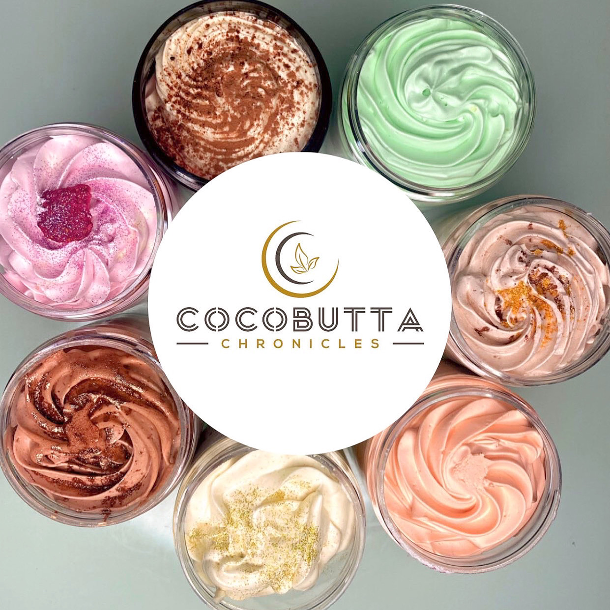 Eight colorful creams in small glass bowls arranged in a circle around a white logo with gold and black text.