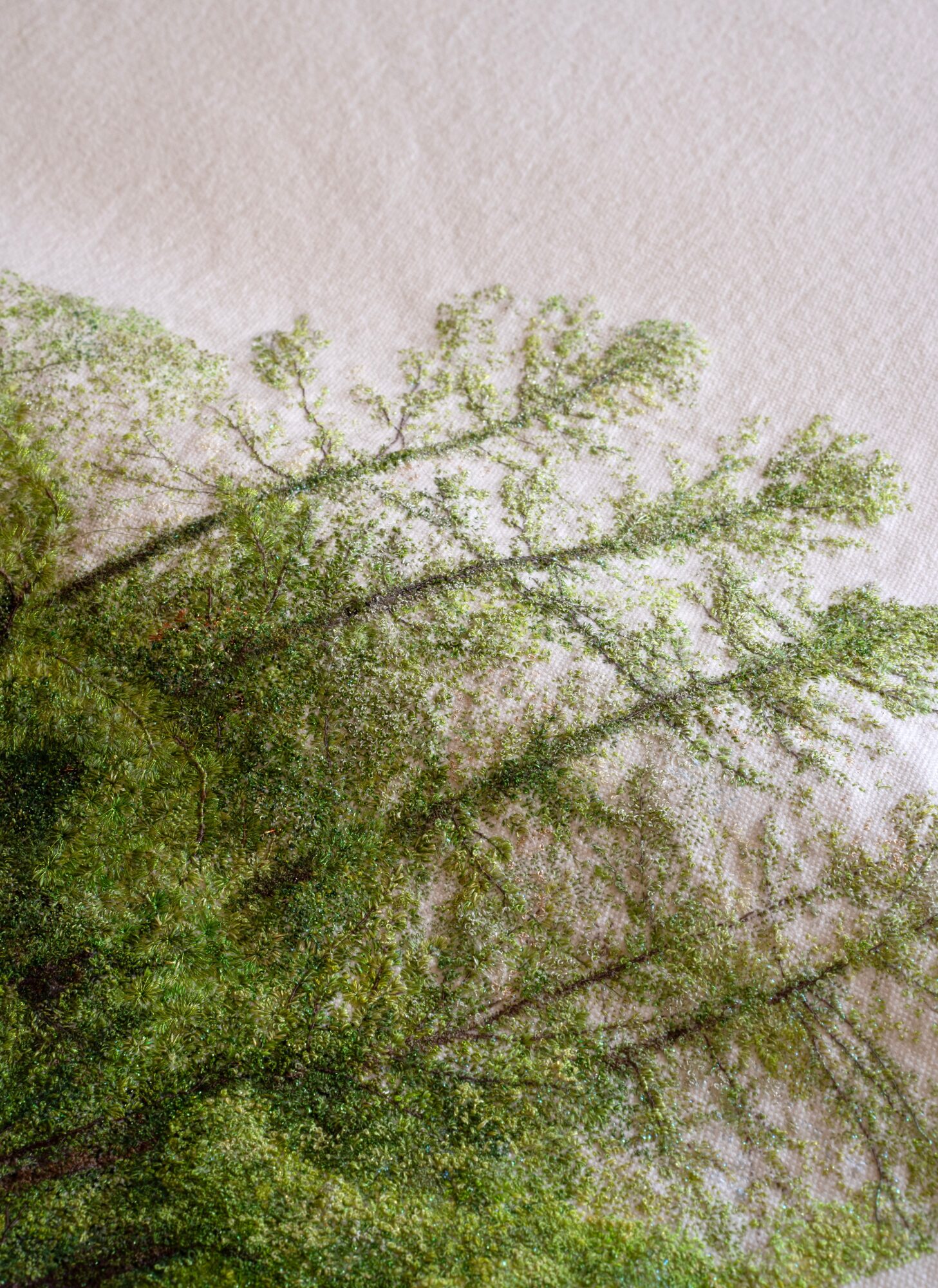 Tree branches with green leaves against a light sky, viewed from below, rotated 90 degrees clockwise.