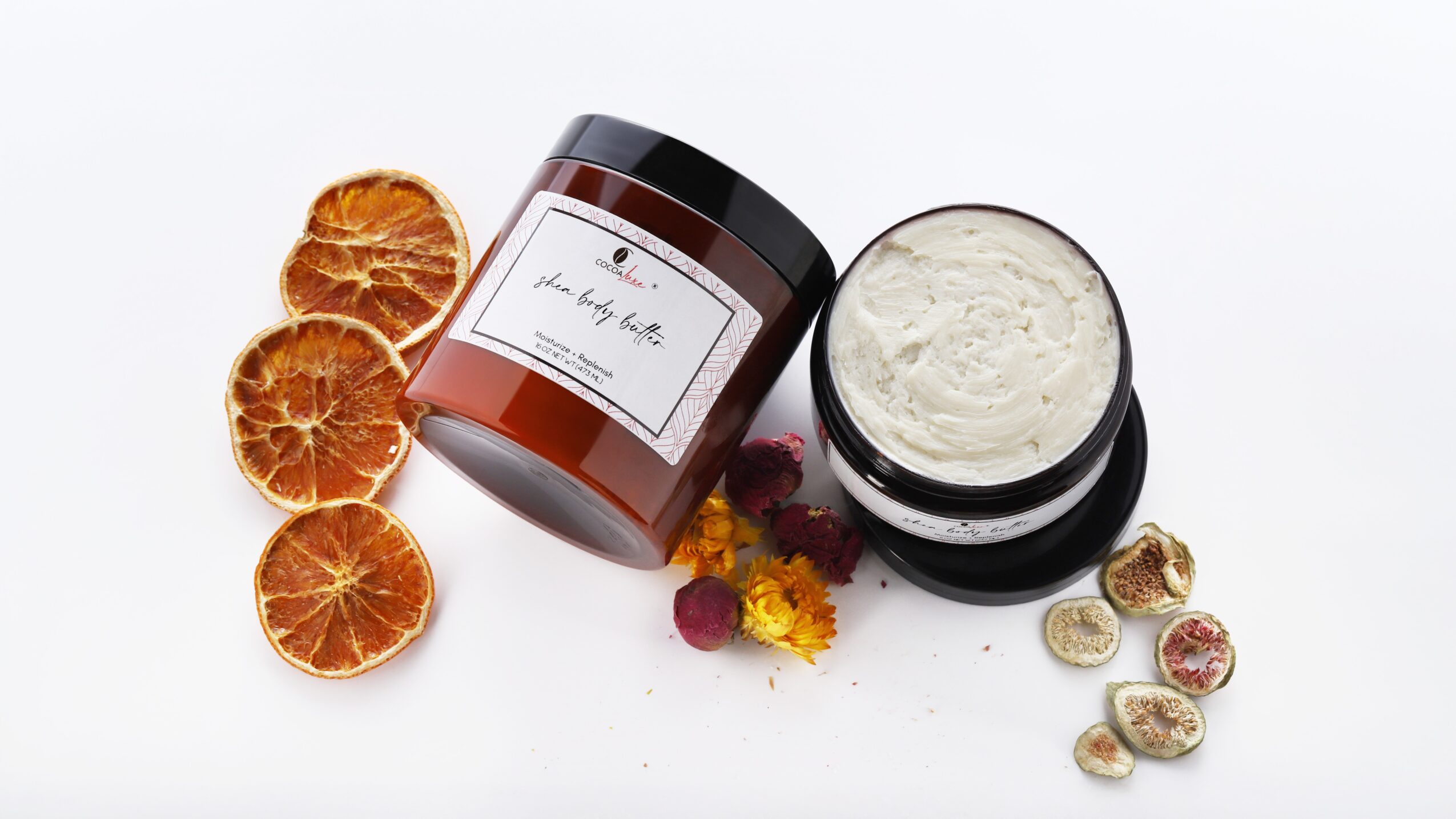 Jar of cream, dried orange slices, and small round candies on white background.