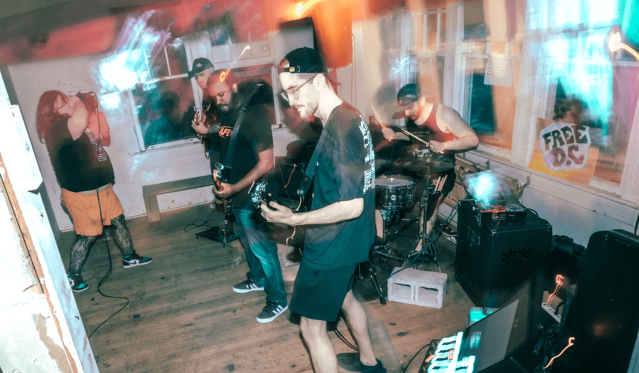 Group of people playing video games in a room with colorful lights and a sign that says 'Free DS'.