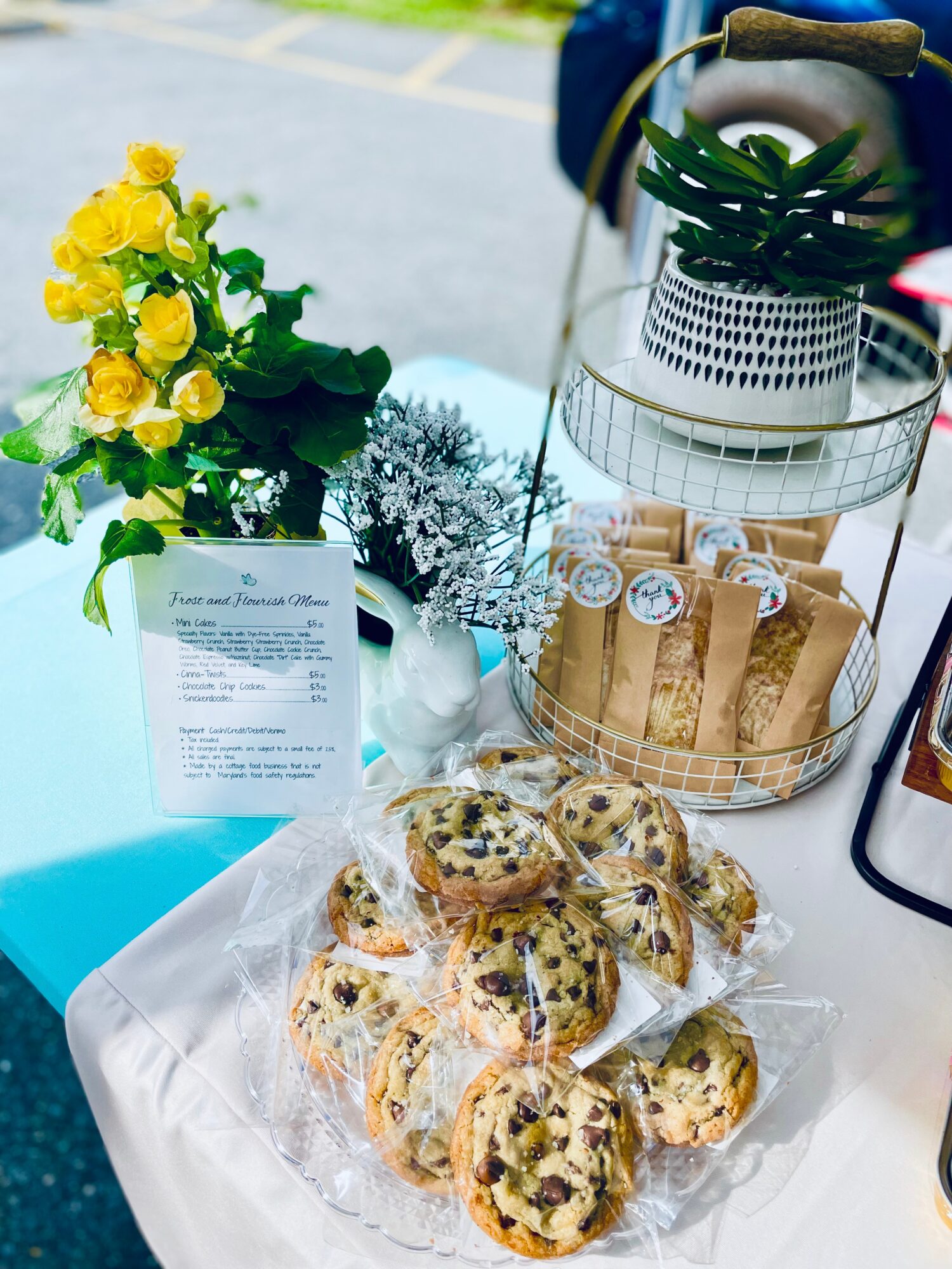 Plate of blueberry muffins on a table with a yellow flower arrangement and decorative items in the background.