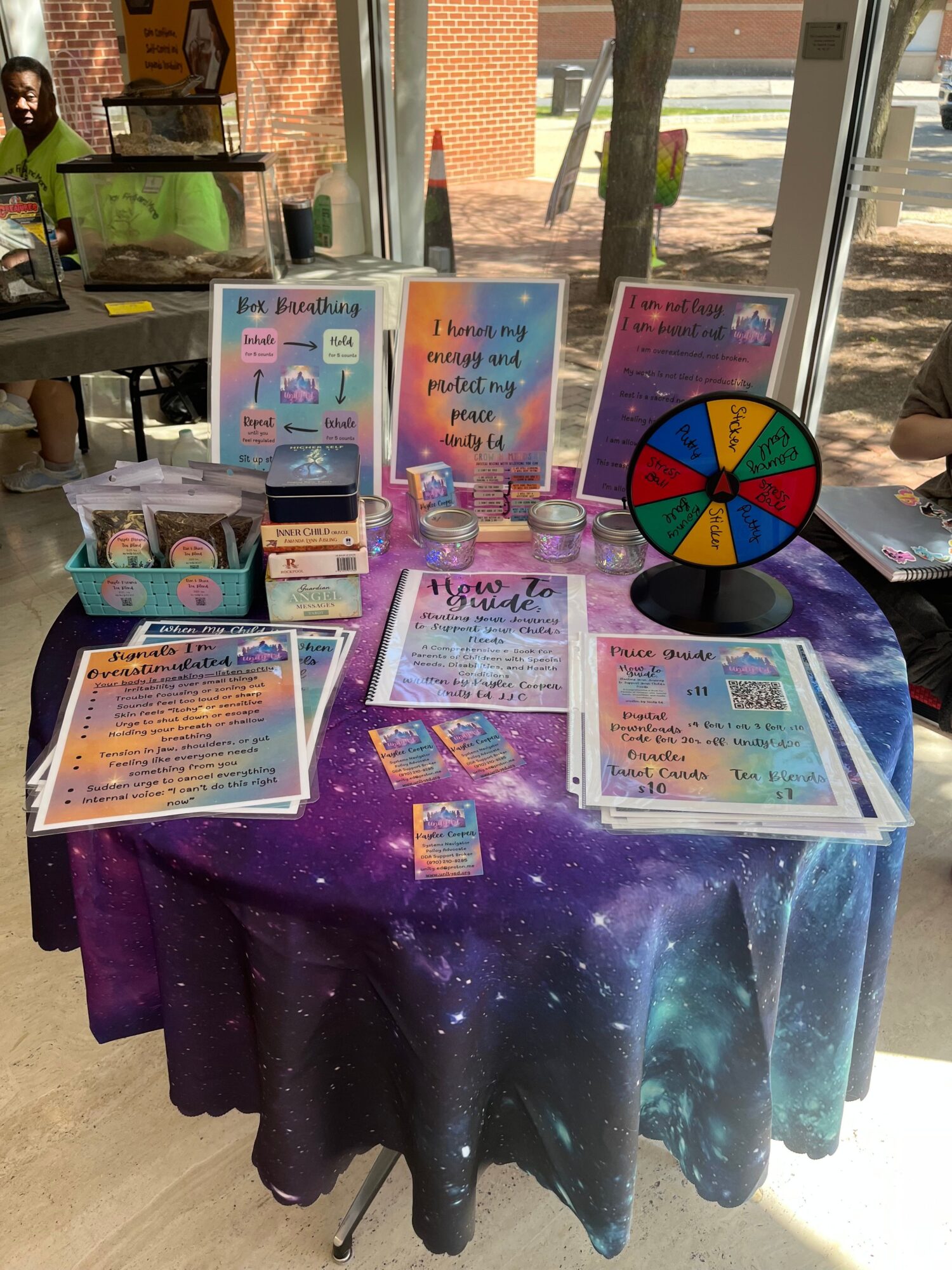 Colorful display of illustrated cards, a prize wheel, and small items on a galaxy-patterned table.