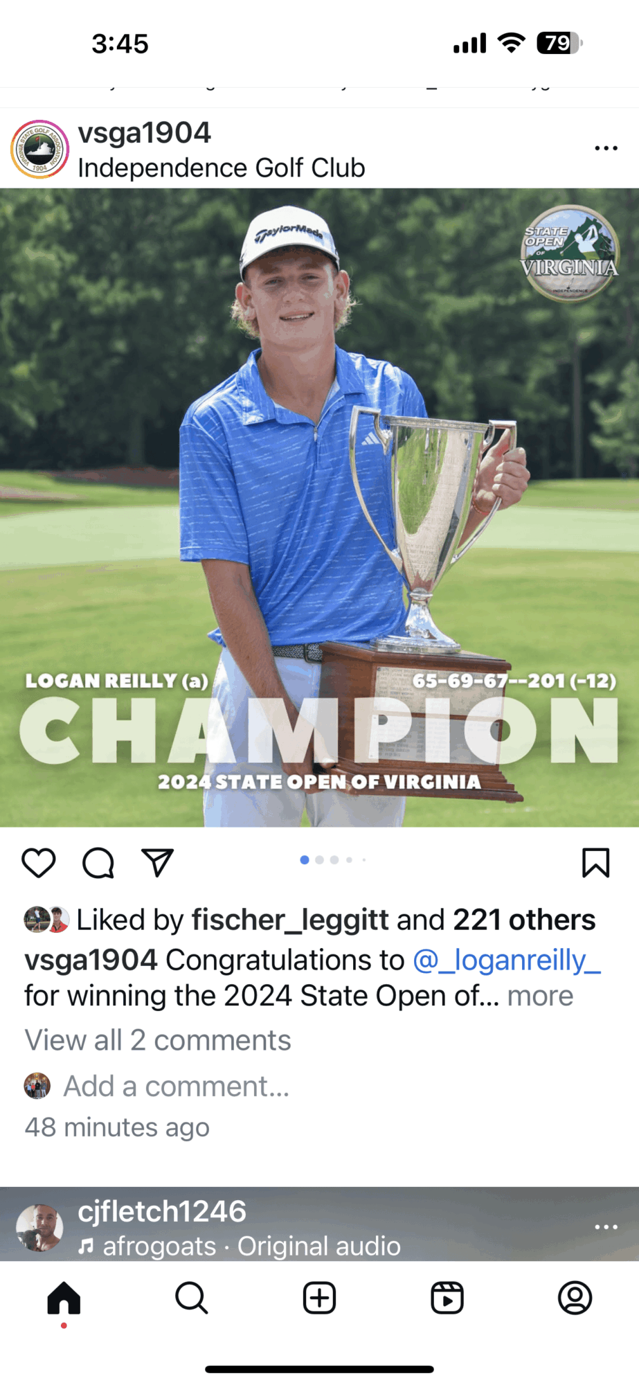 Young golfer holding a trophy on a golf course, wearing a blue shirt and white cap, celebrating victory.