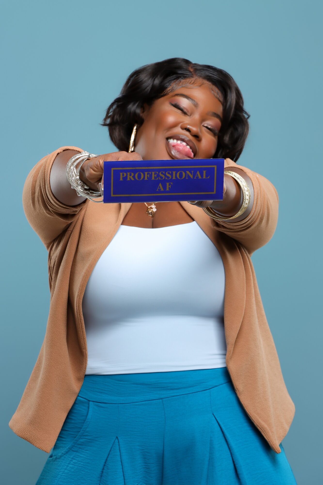 Person smiling and holding a blue plaque labeled “Professional AF” against a blue background.